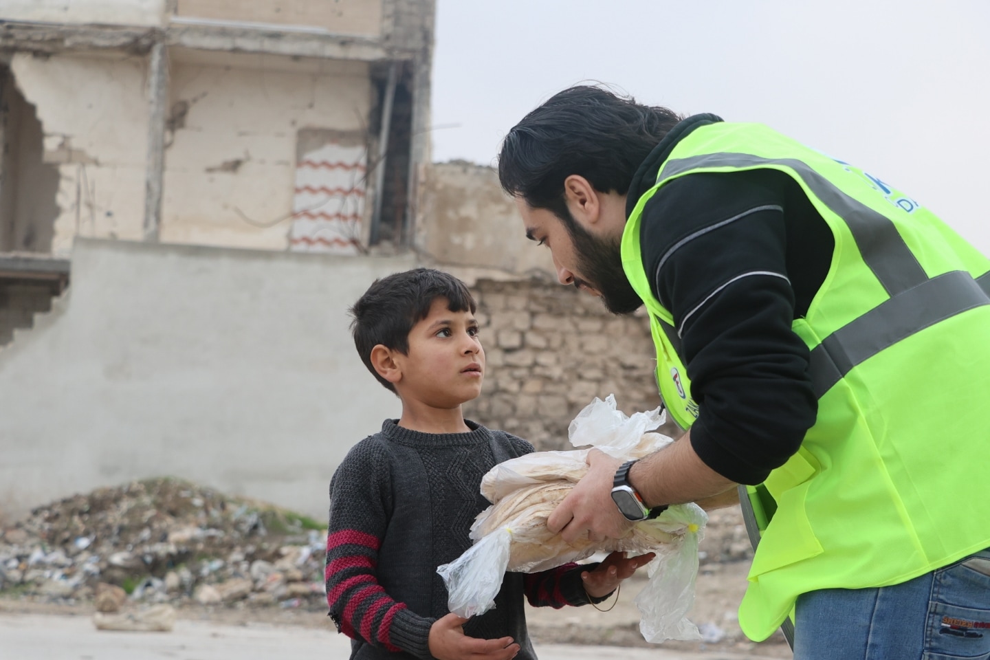 With a reassuring word and a bag of fresh bread, a Syrian child is given hope