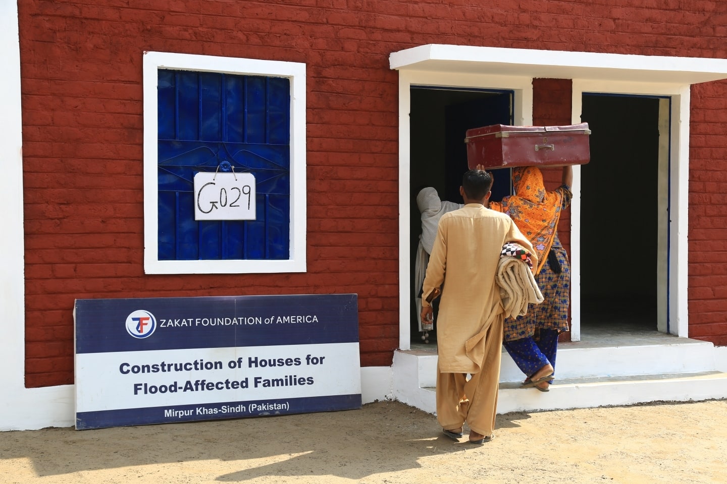 A family in Mirpu Khas, Pakistan moves into their new home after losing theirs to the floods.