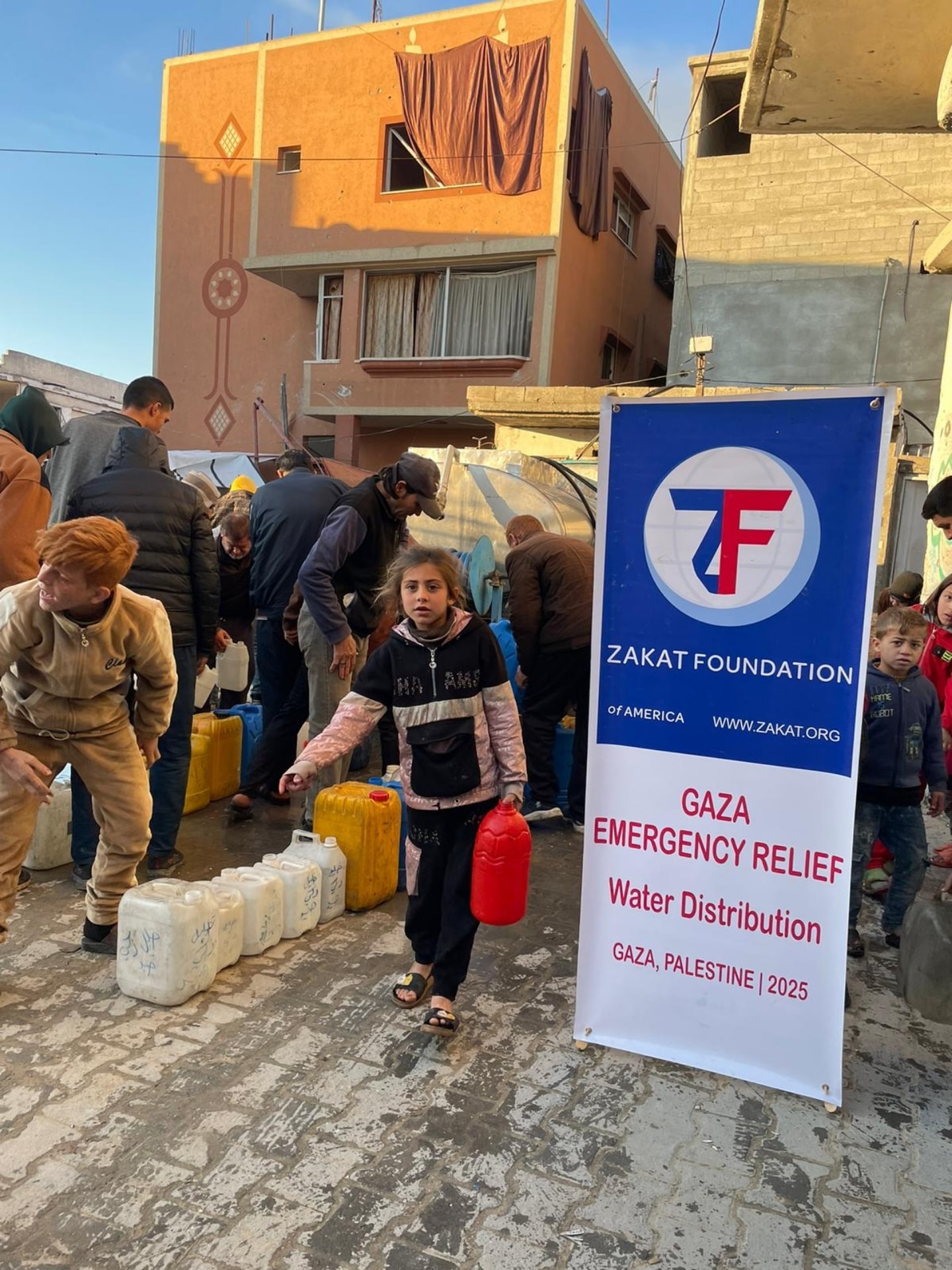 People in Gaza, Palestine line up to collect fresh, clean drinking water at our distribution site.