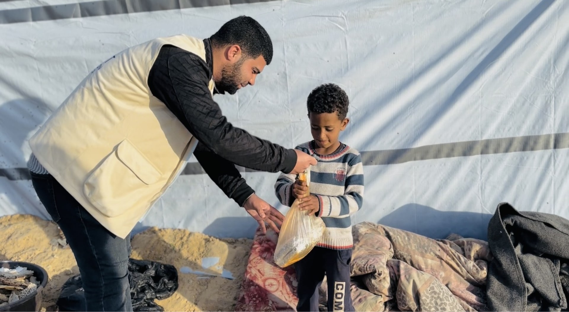 A young boy in Gaza receives a food package to take back to his family.
