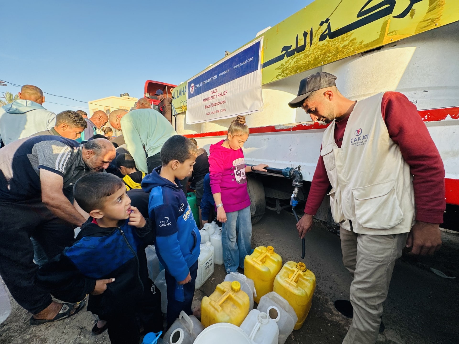 Families in Gaza gather to collect clean drinking water.