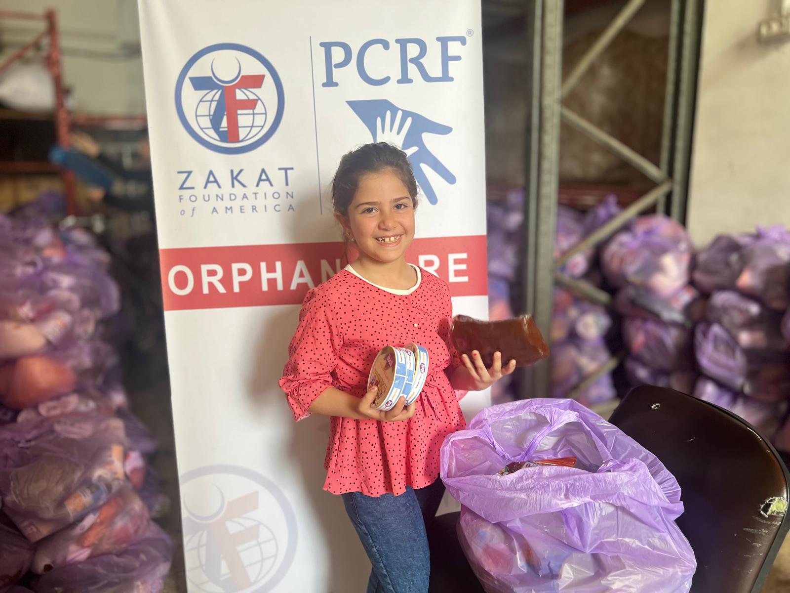 A young Gazan girl is all smiles after being provided essential food supplies.