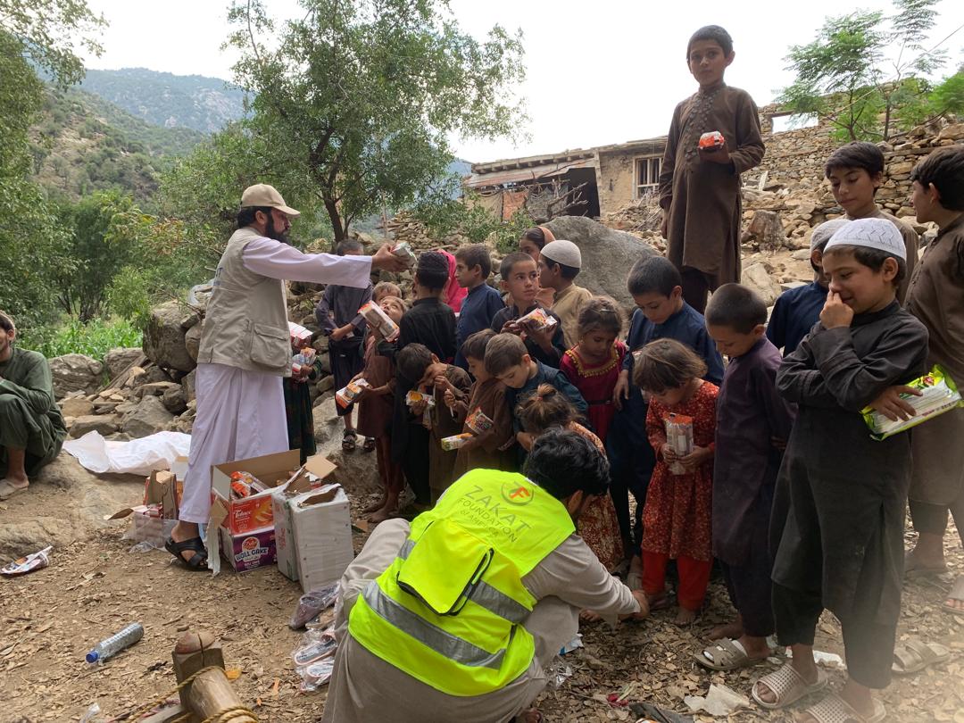 Afghan children gather around our team to receive essentail food items as the search for survivors continues