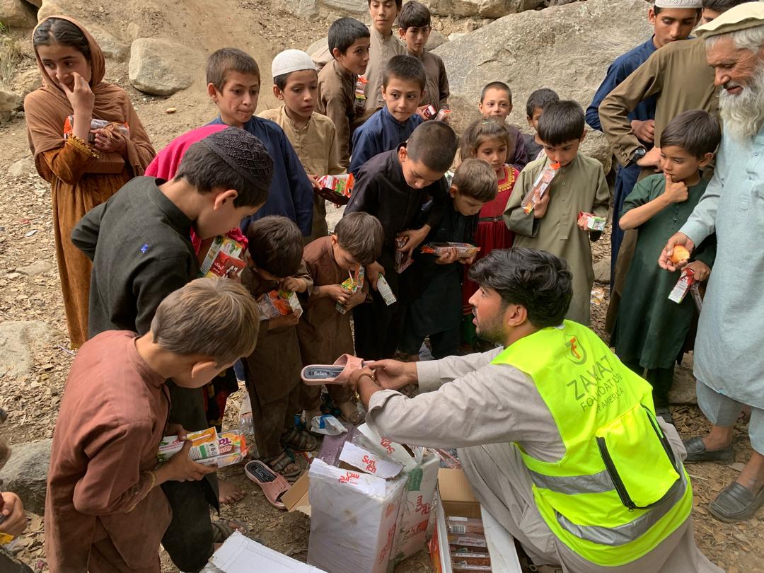 Children gather around our team member in Afghanistan for shoes and food