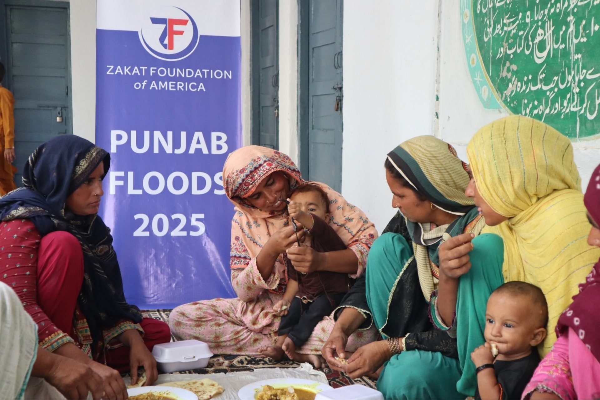 Displaced Pakistan flood affected families eat nourishing meals with their children.