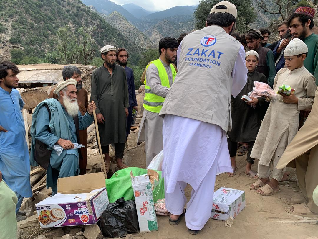 Families surround our team member as emergency food is distributed to earthquake survivors