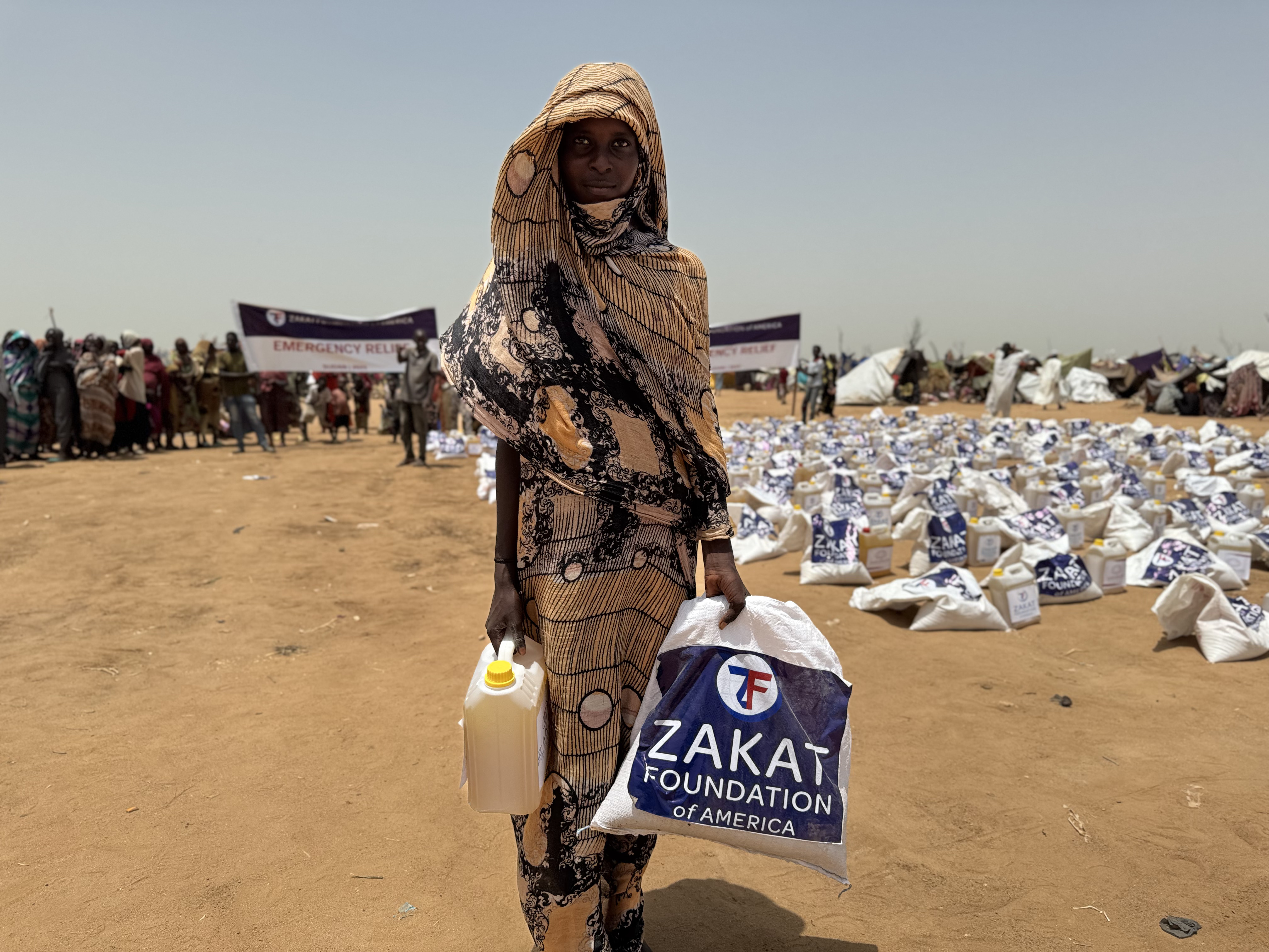A young women from Sudan takes home food items to help feed her displaced family