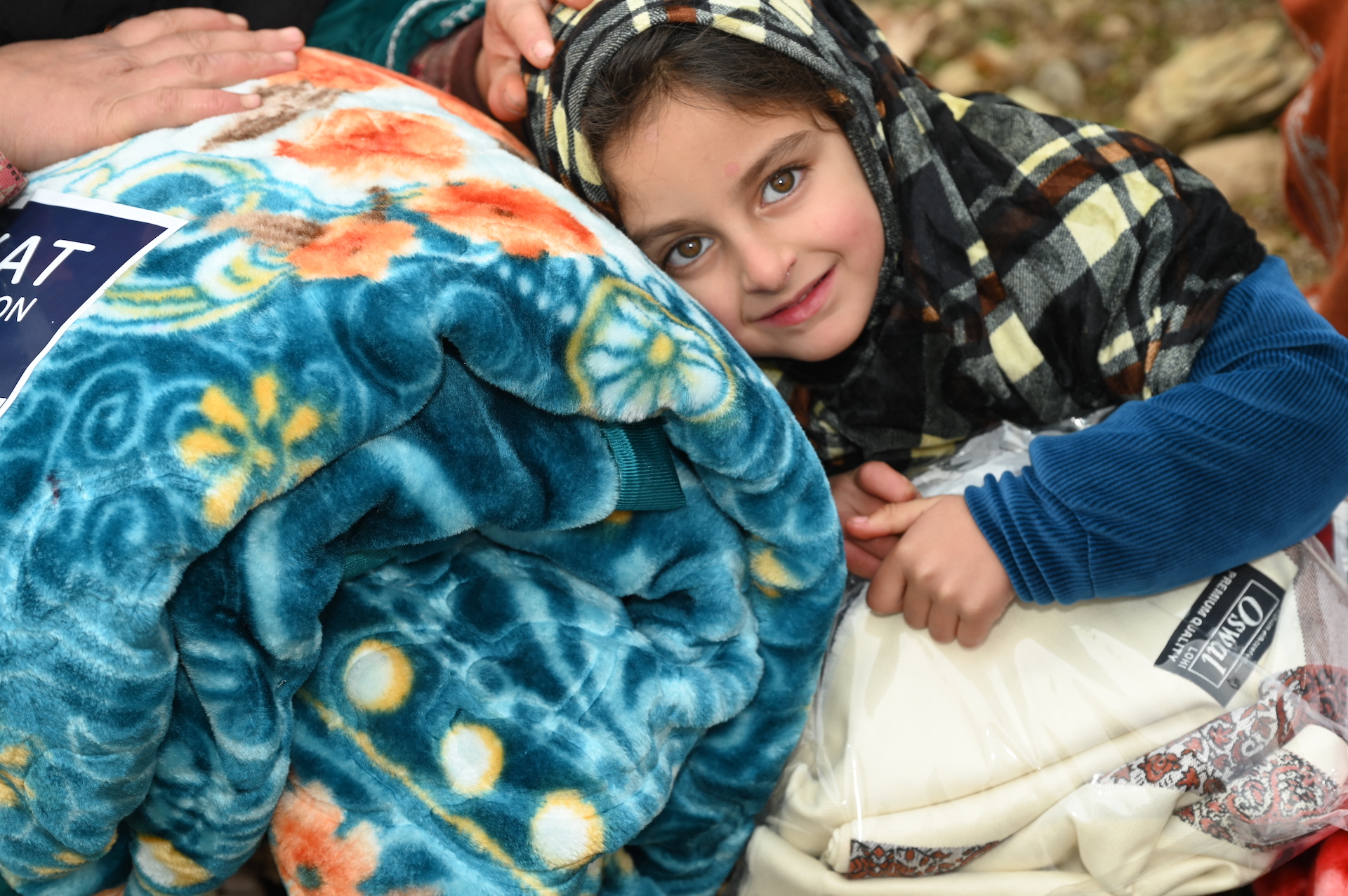 A child in Kashmir, India feels the warm you delivered with a blanket at our distribution site