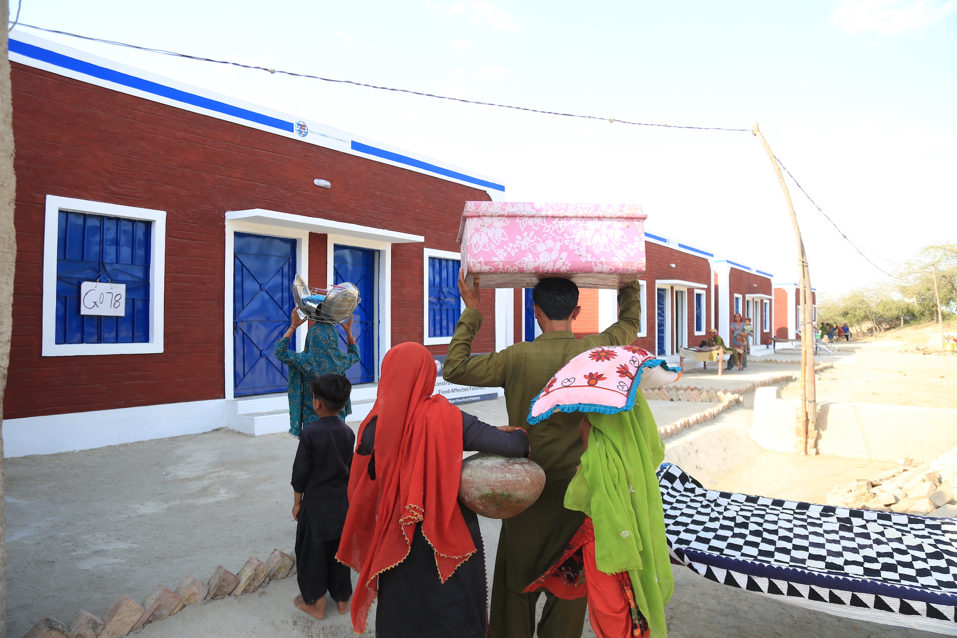 A family excitedly enters their newly build home after having lost theirs to flood waters during monsoon season