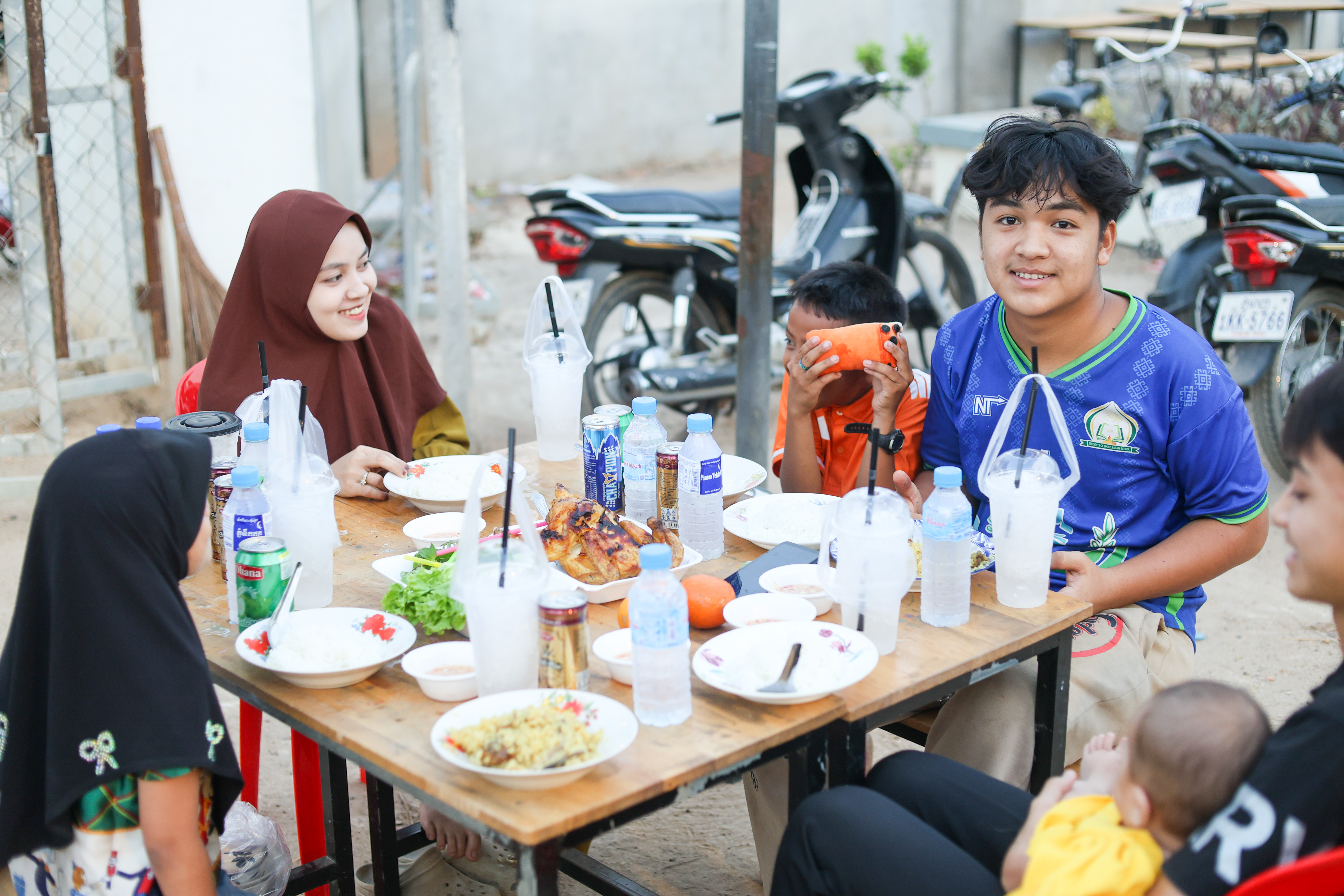 A family in Cambodia gathers around our iftar meal distribution to break their fast