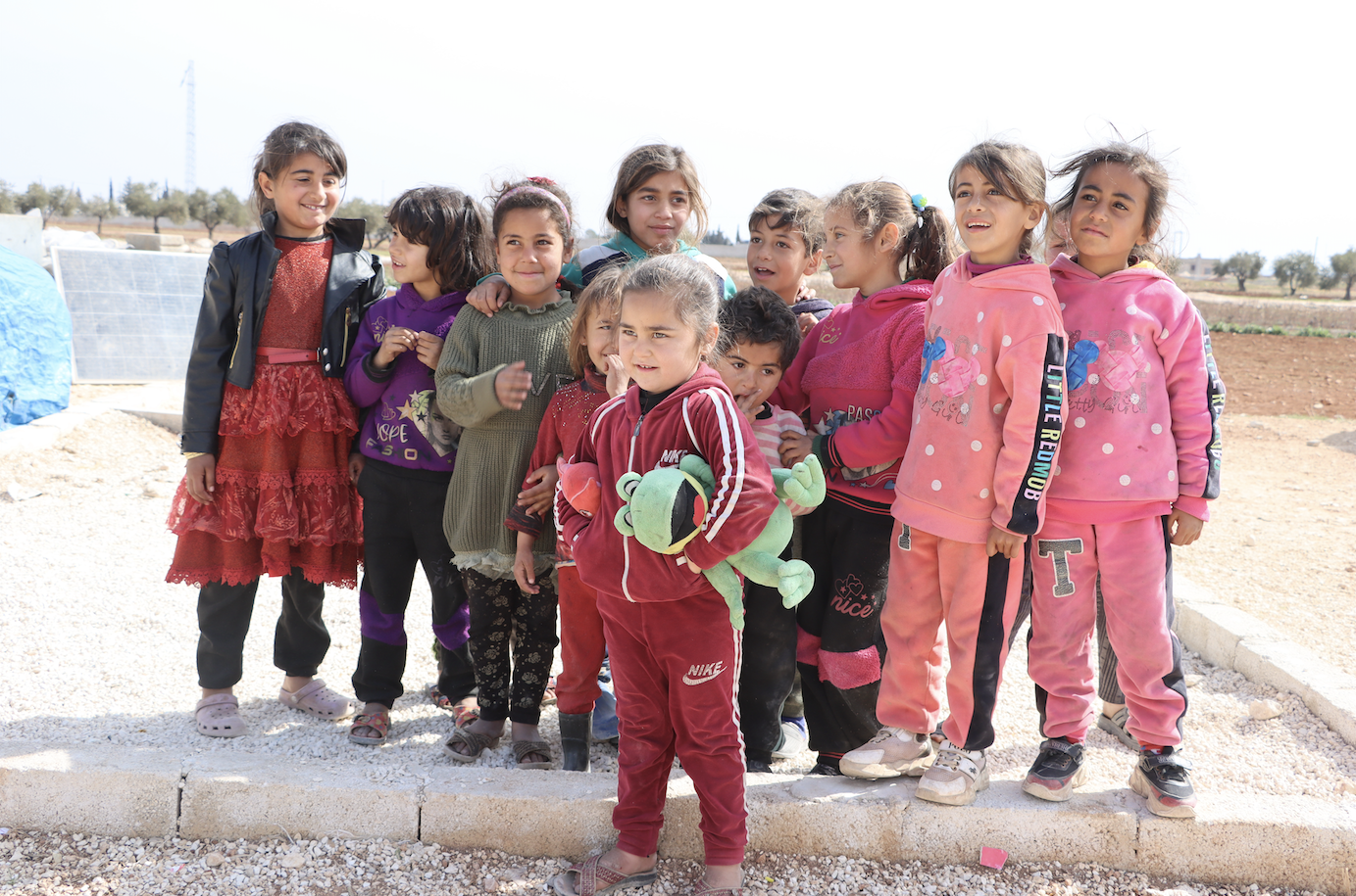 A group of Syrian children look on as our team distribute food packages