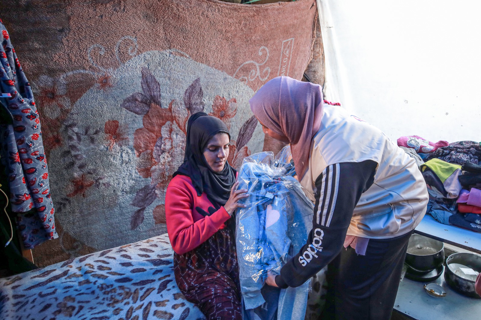 A mother in Gaza receives a warm coat to protect her from the cold