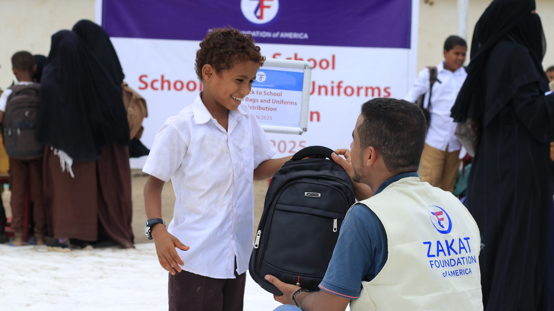 A new backpack with supplies is given to a child in Yemen at the start of the school year
