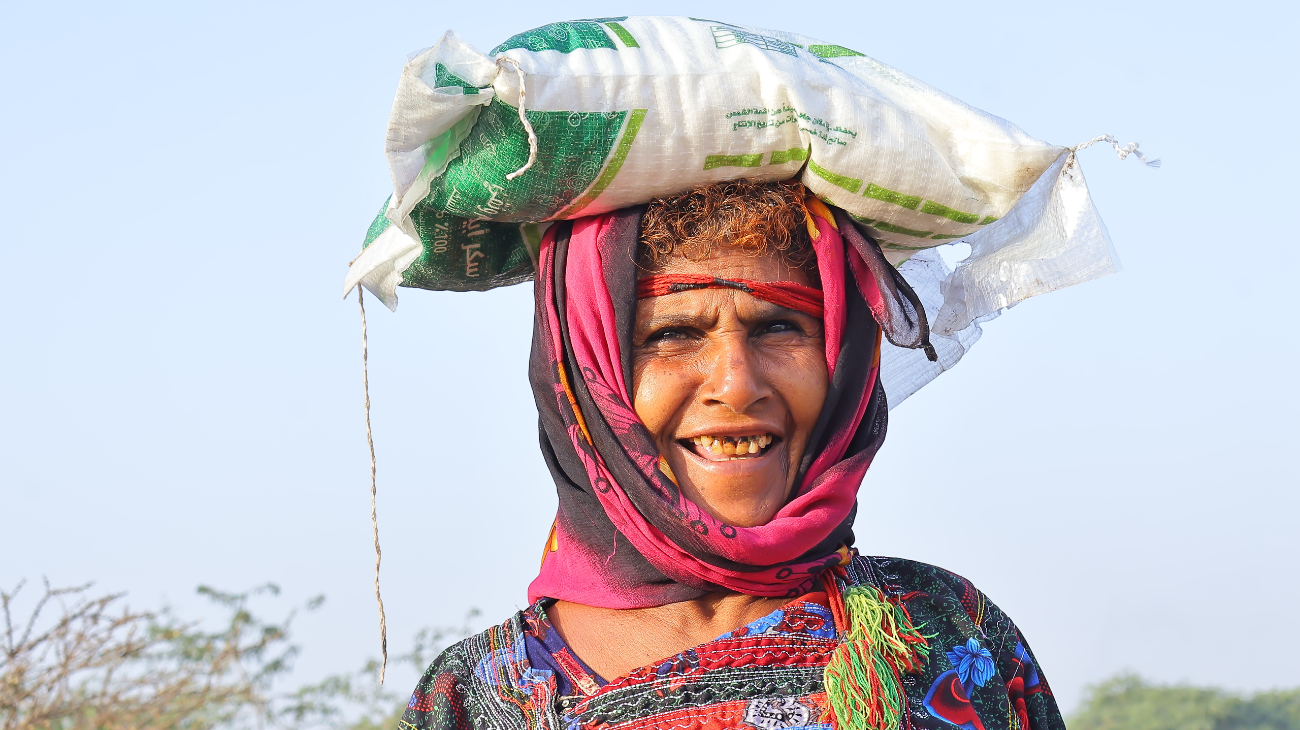 A Yemeni woman smiles after receiving her Ramadan food package