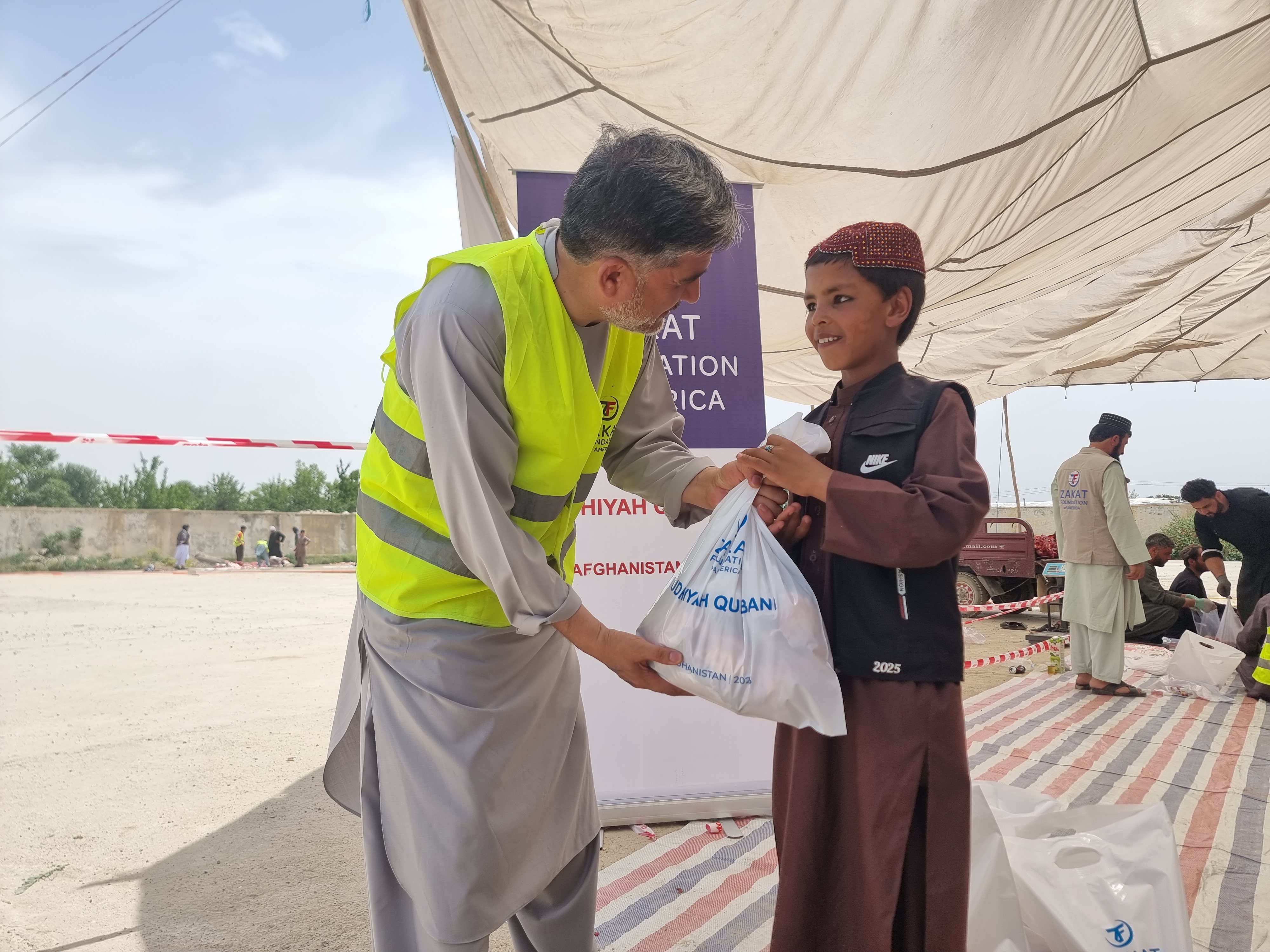 A young boy in Afghanistan collect Qurbani meat from our team