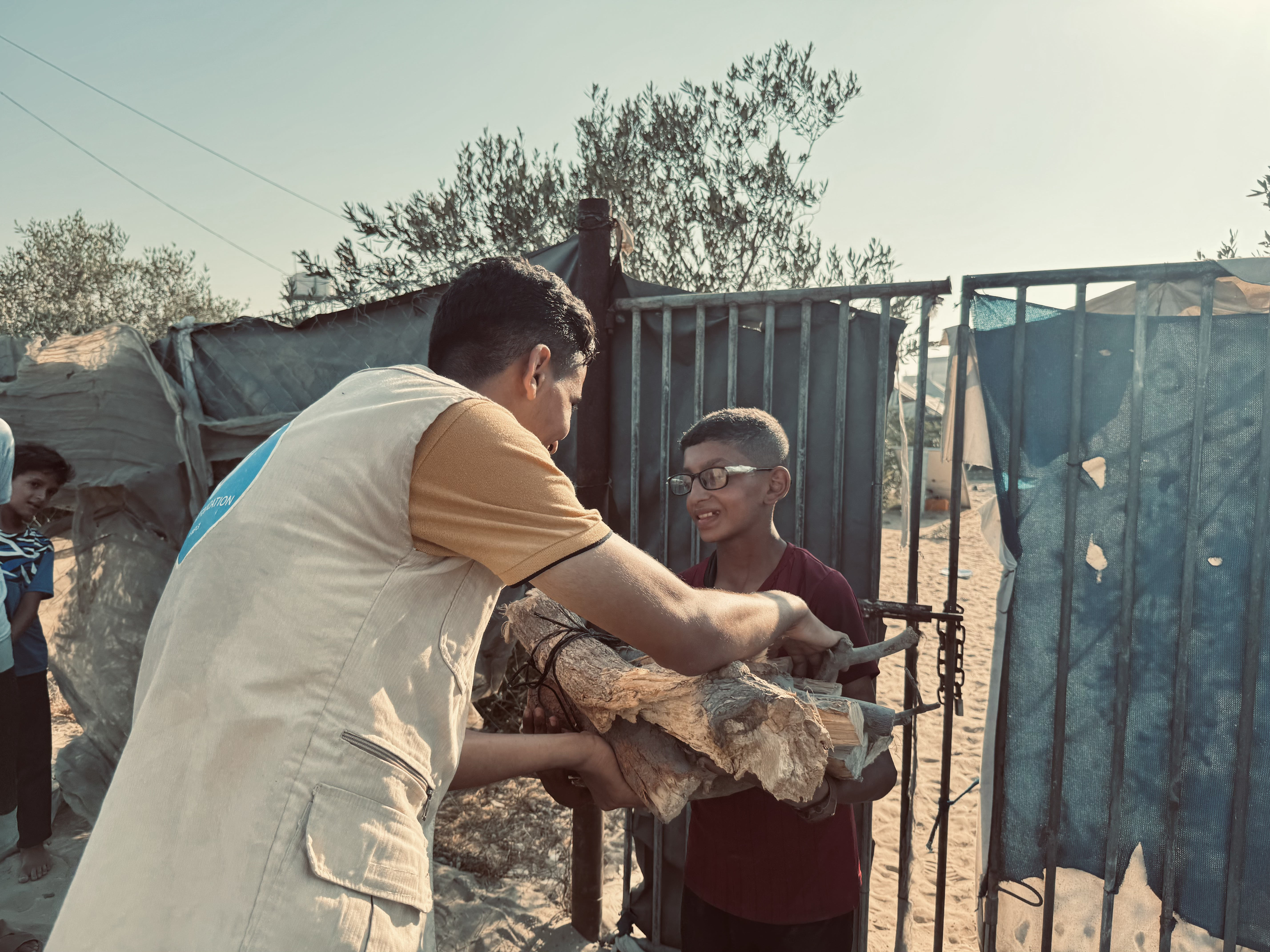 A young Gazan boy takes firewood from our team to keep warm and cook meals