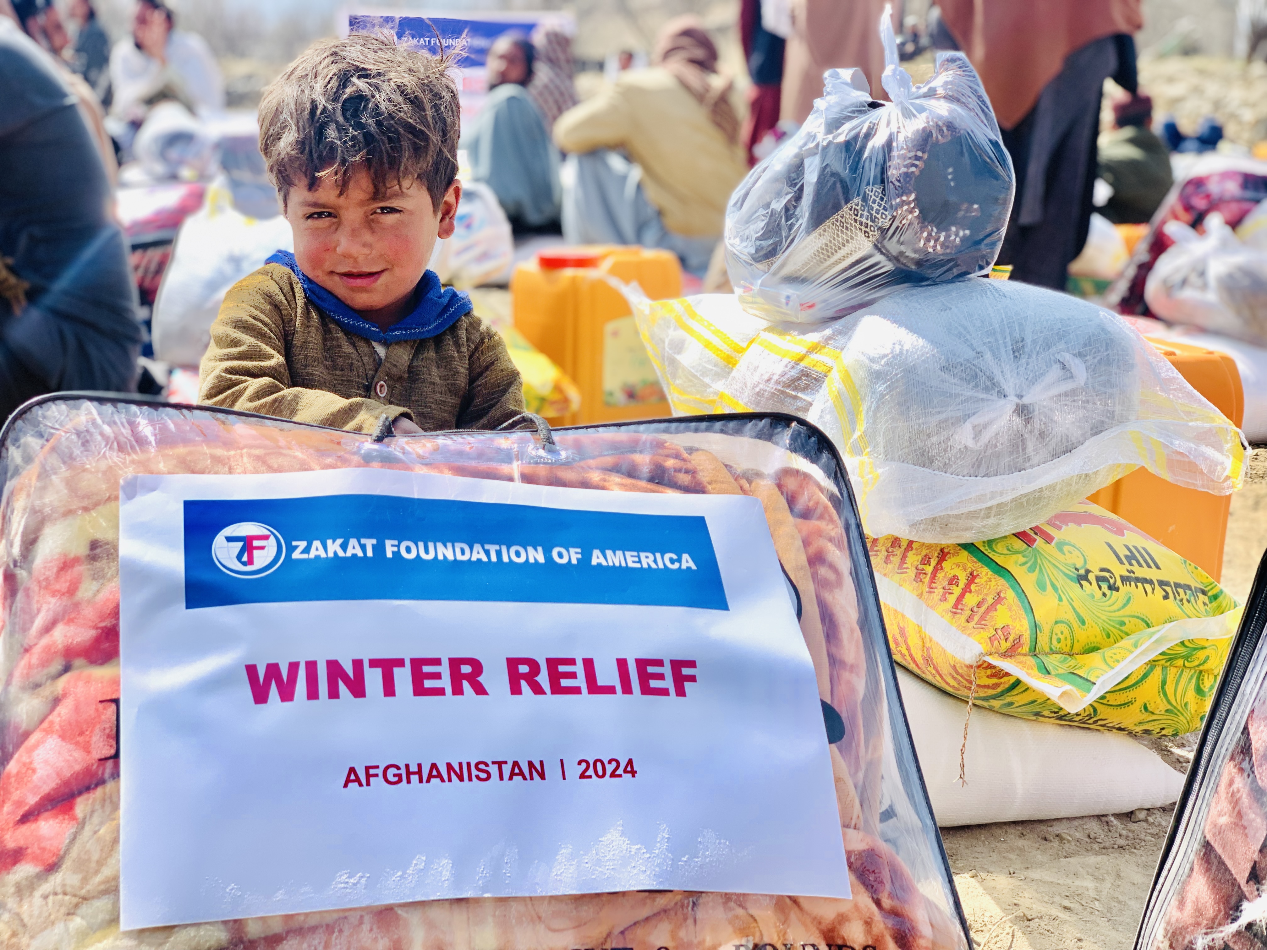 An Afghan boy holds tightly to the winter blanket he received to keep him warm