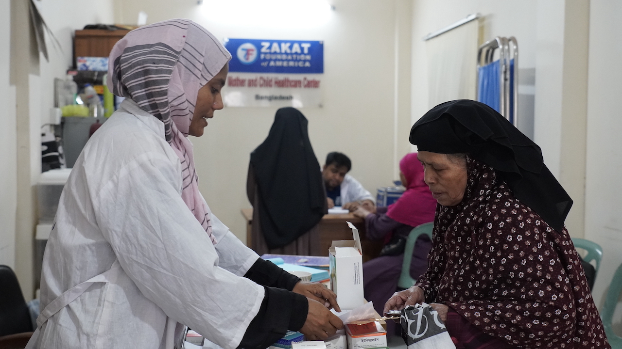 An elderly woman from Bangladesh picks up essential medication at our health care center