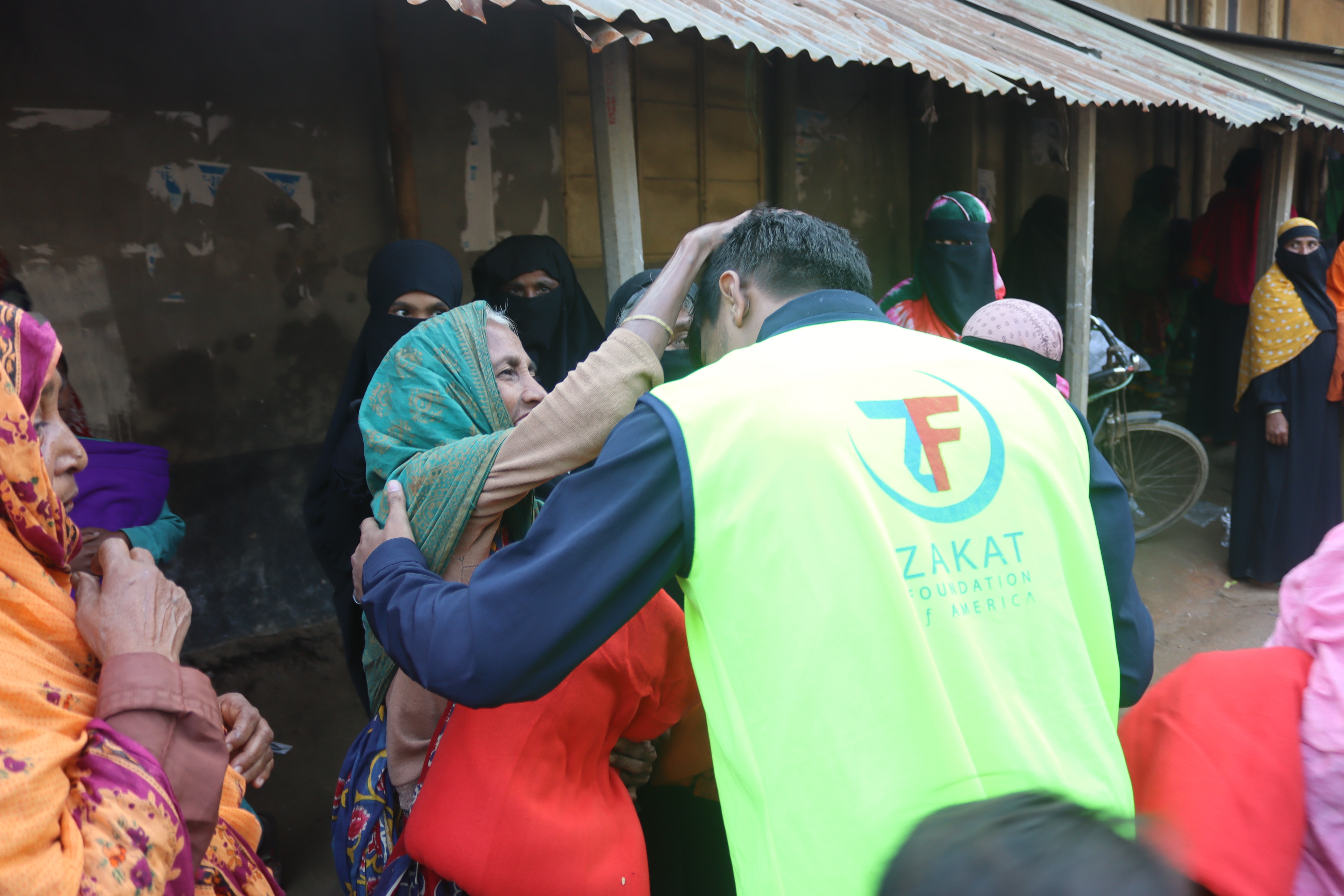 An elderly woman in Bangladesh shows her appreciation to our team for her warm winter kit