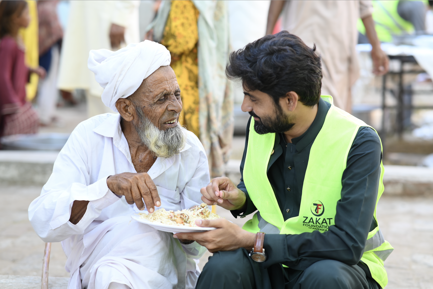 An elderly man affected by the Pakistan floods enjoys a heartwarming meal with our team member