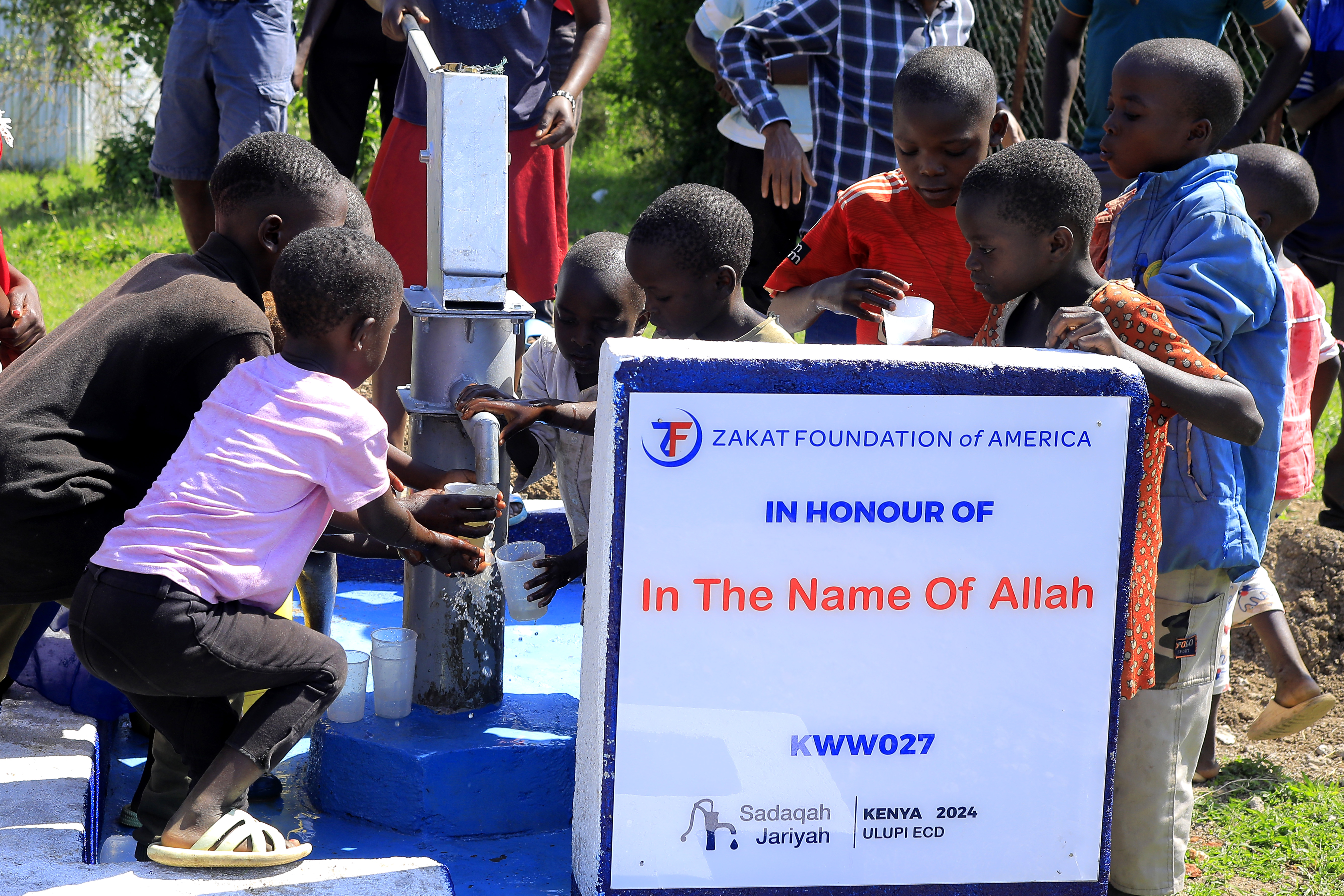 Children in Kenya rush to gather fresh, clean water from a newly constructed well