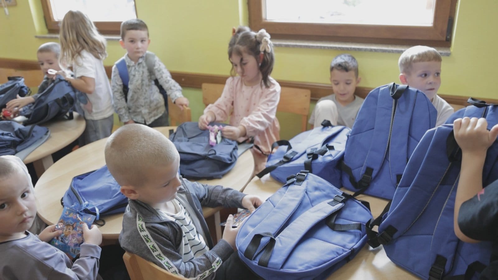 Children take a moment to look through their newly donated school supplies