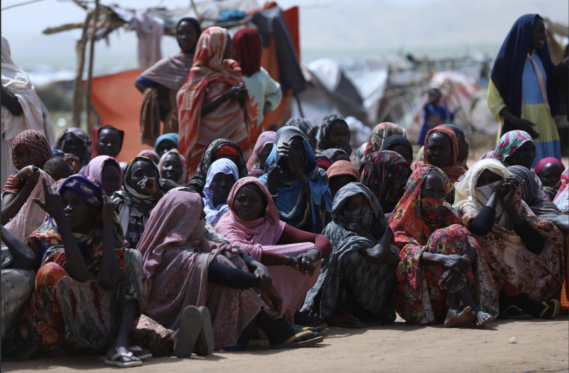 Displaced Sudanese women wait at our distribution site for emergency food relief to help feed their families