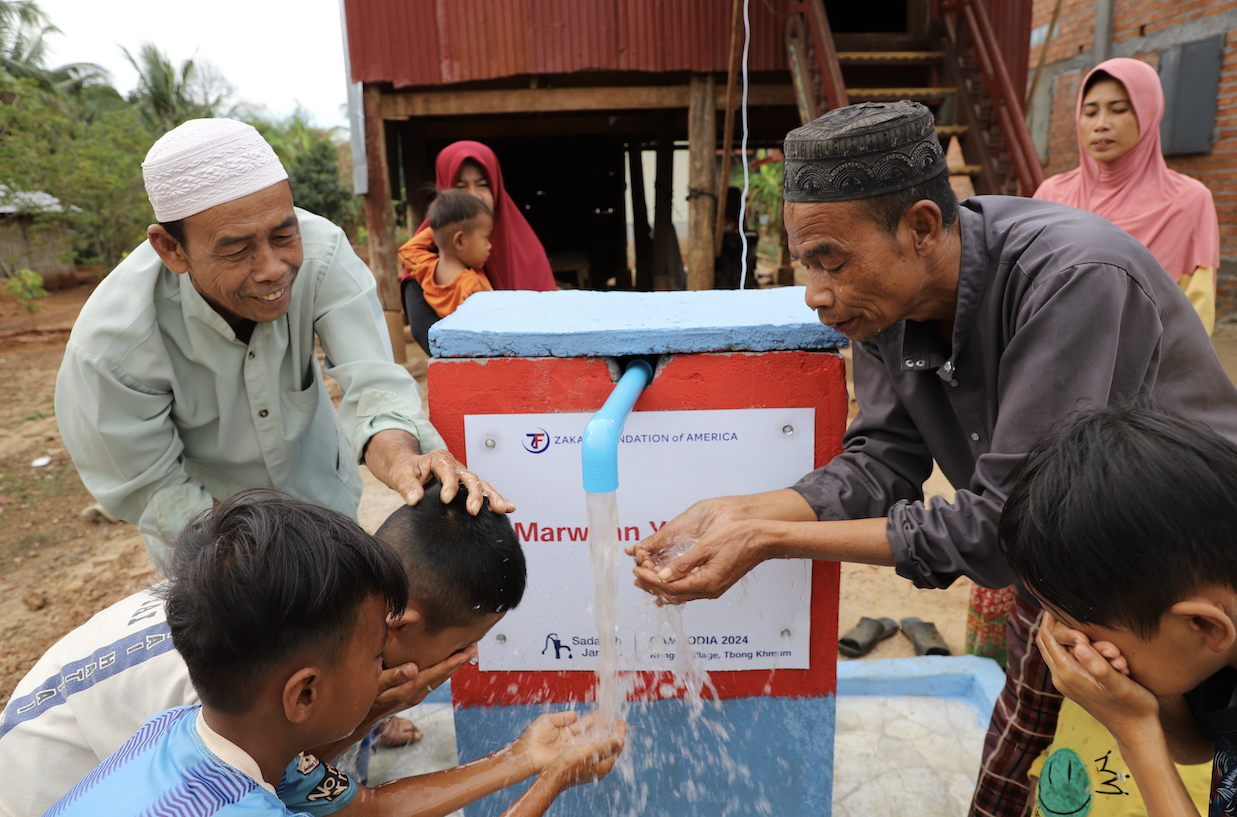 Families in Cambodia rush to get a handful of fresh water to quench their thirst