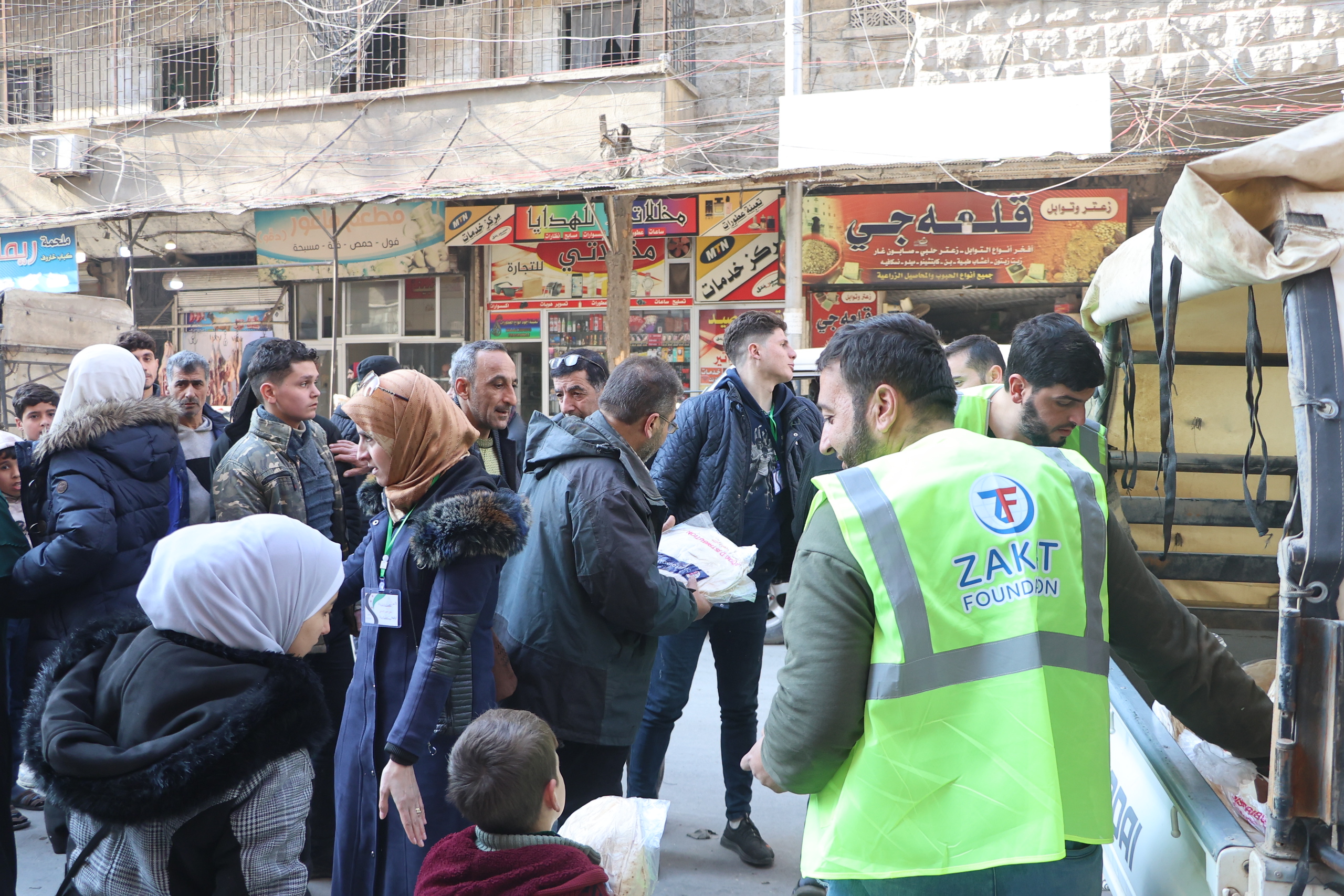 Families in Syria gather around our team to collect warm bread