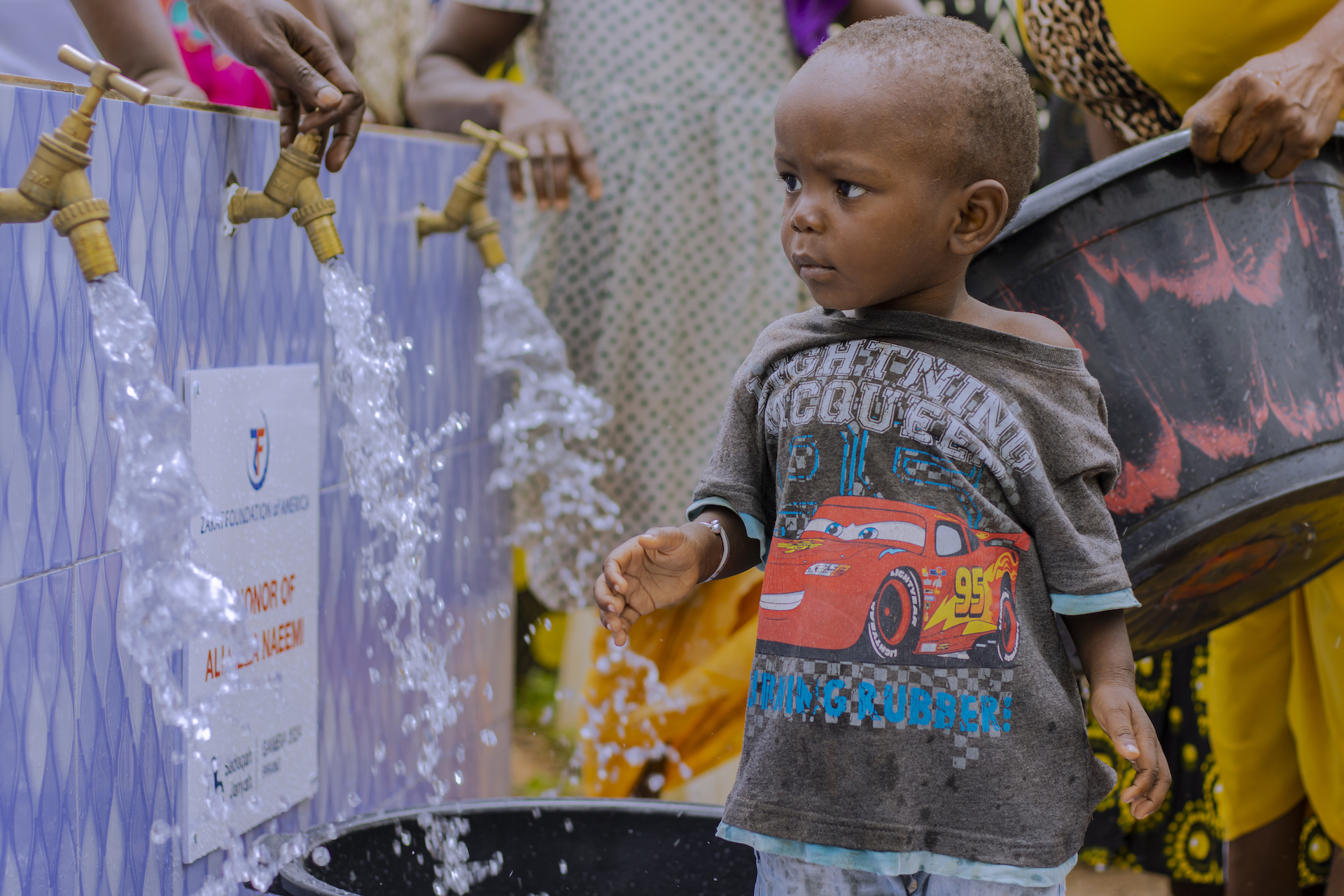 Families in The Gambia collect tubs of water to take home and enjoy