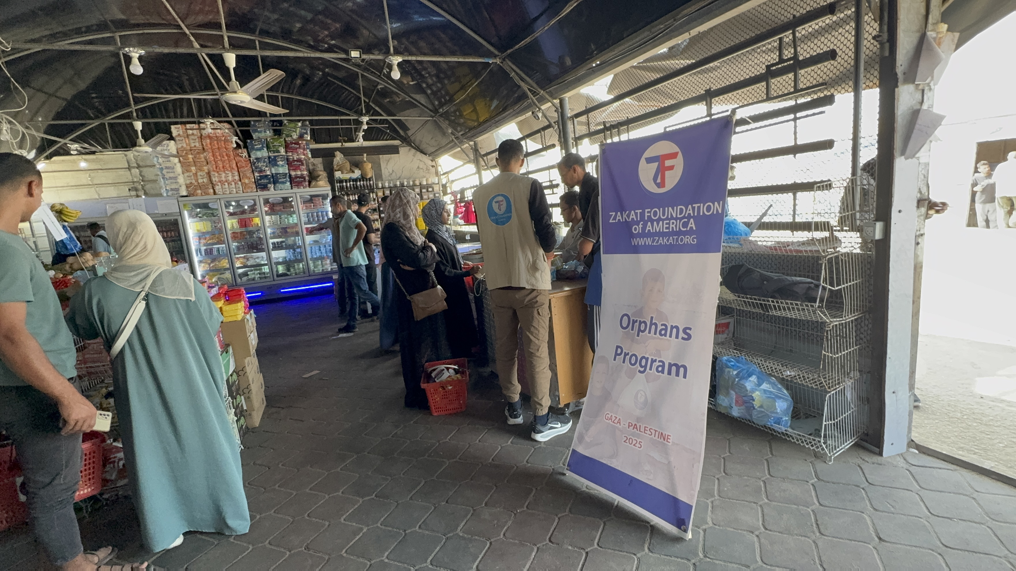 Guardians of our sponsored orphans collect food essentials at our distribution center in Gaza