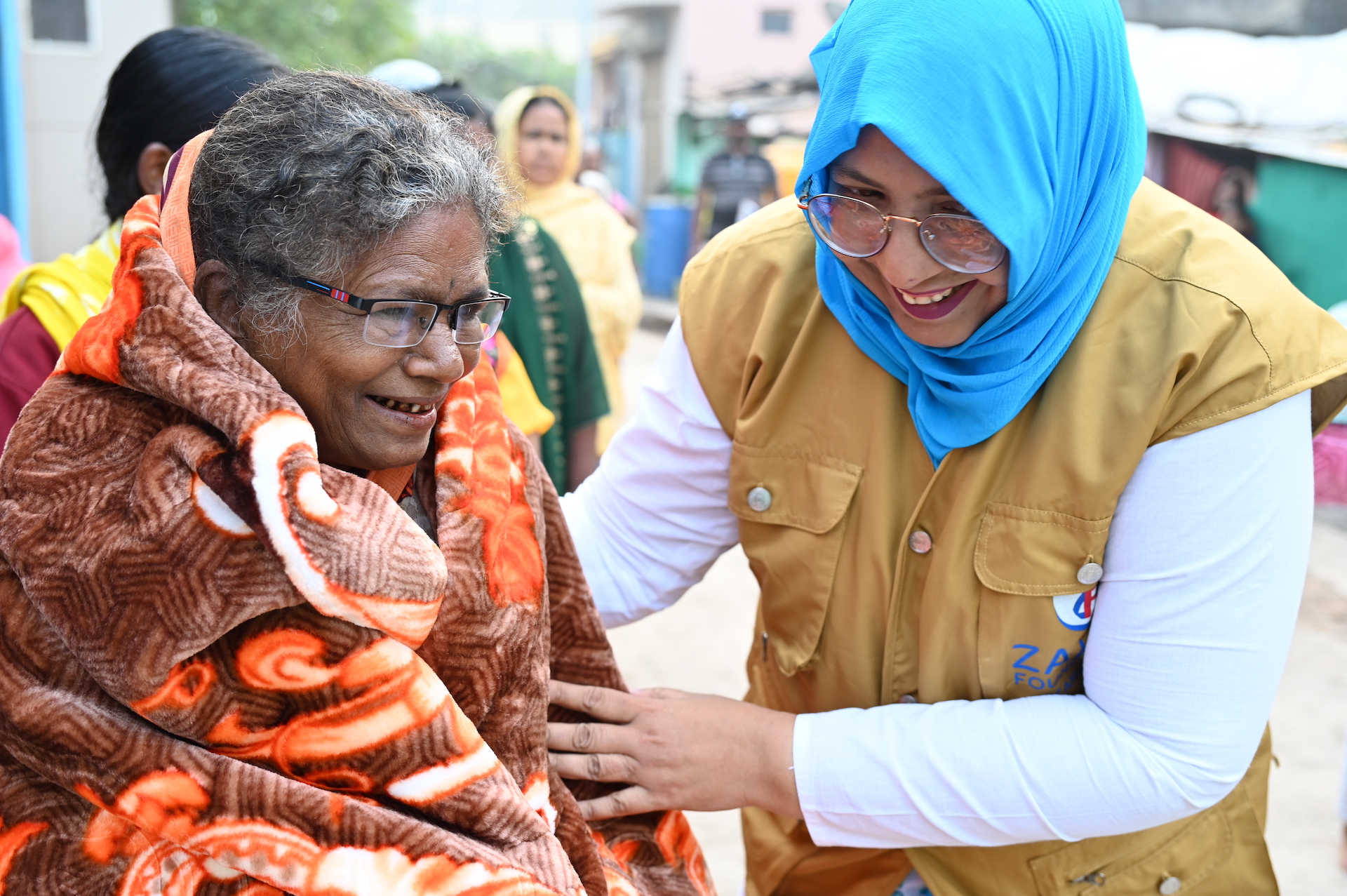 Our team member in India wraps an elderly woman in a blanket for protection from the chill