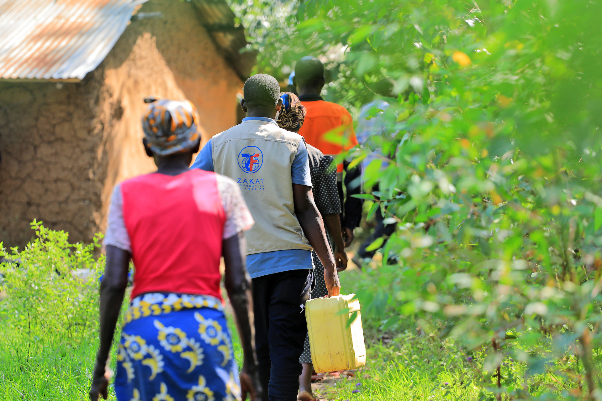 Our team members in Kenya assist families in carrying home clean drinking water from our water site