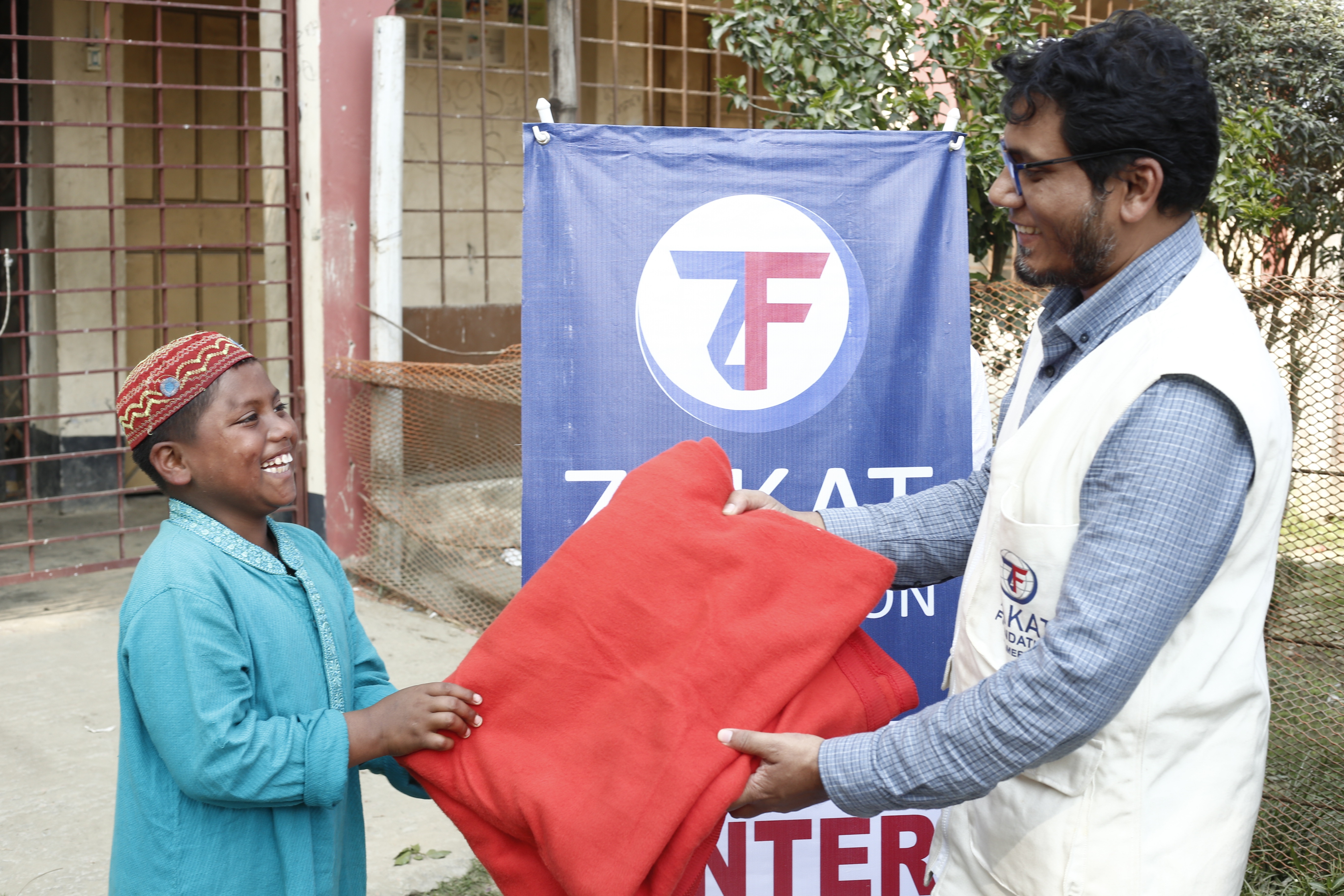 Warmth delivered in Bangladesh as a boy receives winter staples from our field team